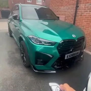 Green BMW M3 Touring on a driveway with the key held up after remote start coding